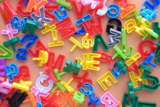 colorful plastic letters on orange background