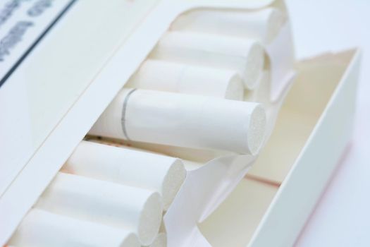 A closeup of open white pack of cigarettes on a white background.