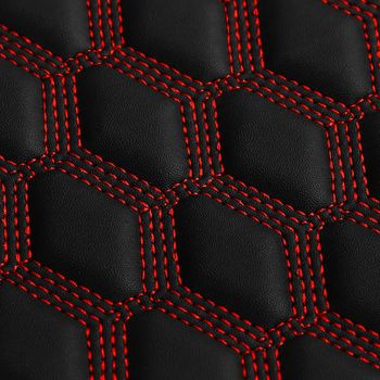 Texture of black leather background with square pattern and red stitch, macro