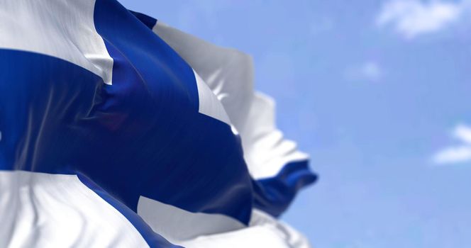 Detail of the national flag of Finland waving in the wind on a clear day. Democracy and politics. North European country. Selective focus.
