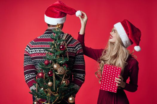 cheerful young couple in Santa hats Christmas tree toys decorations. High quality photo