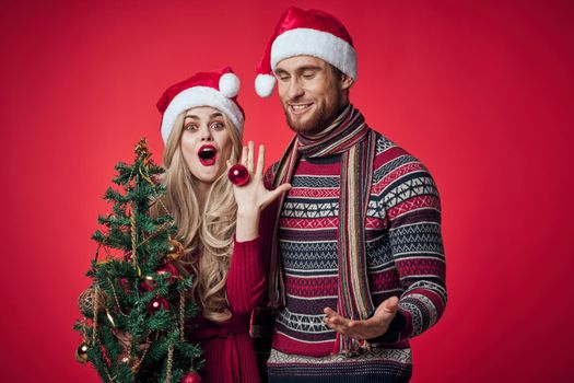 cute young couple celebrate christmas together red background. High quality photo