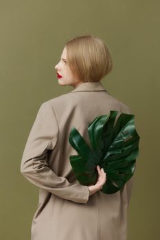 blonde woman red lips palm leaf charm fashion green background. High quality photo