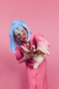 portrait of a woman in blue wig pink dress red lips isolated background. High quality photo