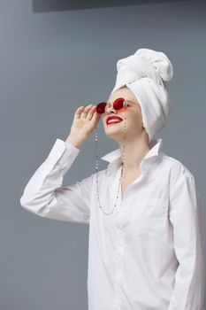 woman red sunglasses cosmetics with towel on head studio model unaltered. High quality photo