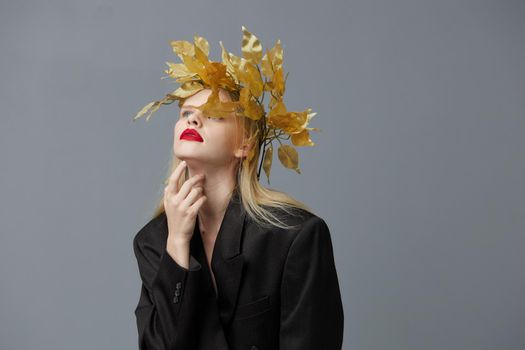 glamorous woman golden leaves on the head in black jacket studio model unaltered. High quality photo