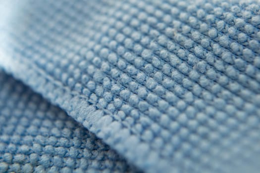 Blue cloth for cleaning the screen of the phone, tablet, TV, glasses. Microfiber structure. Selective focus. Macro filming.