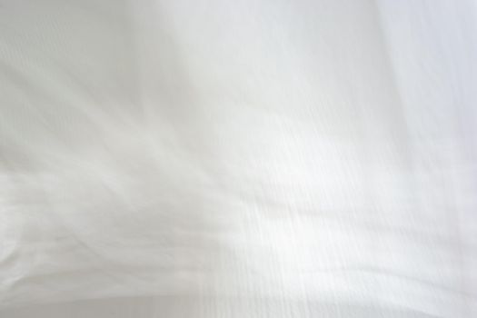 Abstract background, soft blurred shadows from a window on a white concrete wall.