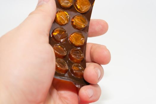 A man holds a used blank blister from under pills in his hand. Health and medicine theme.