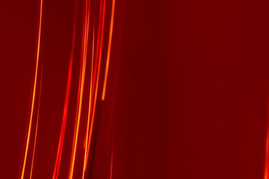 Bright red lines rays on a burgundy background. Abstract backdrop with soft blur. Energy and speed.