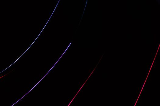 Abstract background of diagonal red and purple lines on black. Light effect.