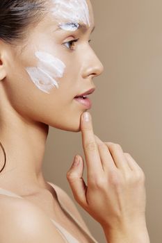 beautiful woman face mask cream clean skin facial scrub beige background. High quality photo