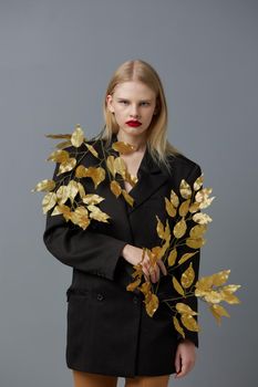 glamorous woman fashion golden leaves in black jacket studio model unaltered. High quality photo