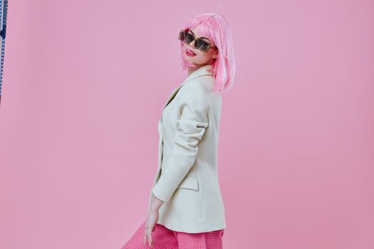 Beautiful fashionable girl wearing sunglasses pink hair posing color background unaltered. High quality photo