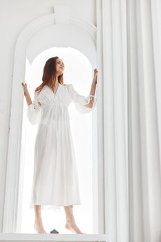 woman in the form of an angel barefoot in the luxury window. High quality photo