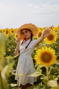 woman with pigtails in a hat on a field of sunflowers Summer time. High quality photo