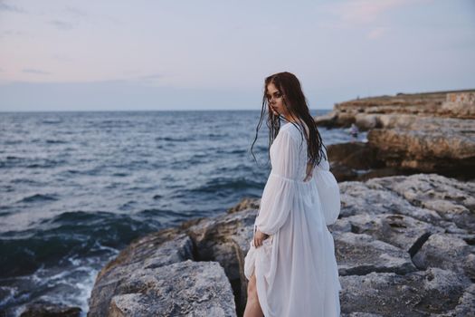 woman in a dress with wet hair stands on the shore of the ocean travel nature unaltered. High quality photo