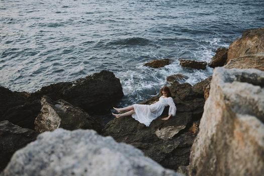 woman lying on rocky coast with cracks on rocky surface view from above. High quality photo