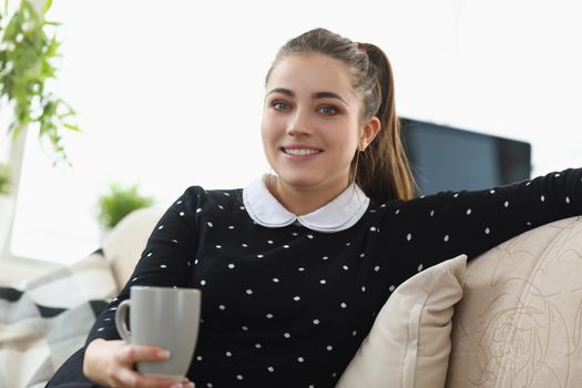 Portrait of beautiful brunette young woman chilling with cup of hot coffee. Lovely lonely woman in good mood. Coffee break, lunch, relax, happiness concept