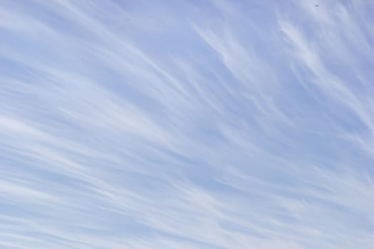 White cirrus clouds on the background gentle blue sky.