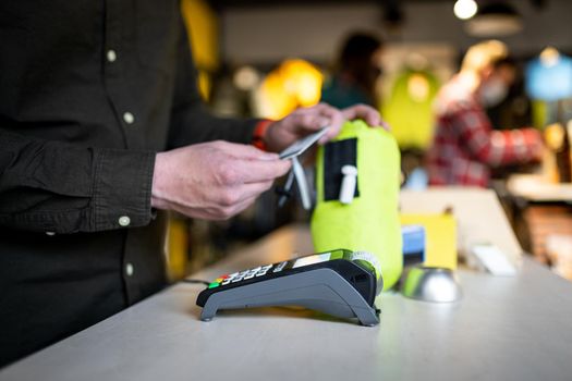 Salesman holds payment terminal while holding receipt for completing purchase. Hands close up. Concept of NFC, business and banking transactions. Payment terminal with paper tape. Bank terminal.