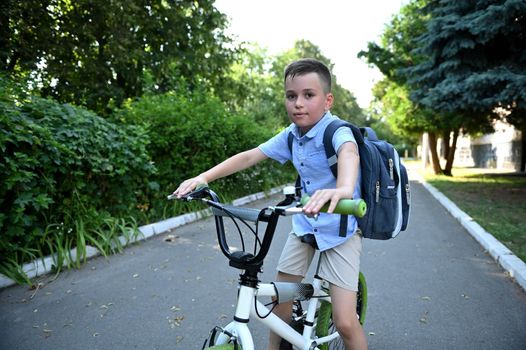 Adorable bicycle boy riding to school establishment. Kids on bike, child biking