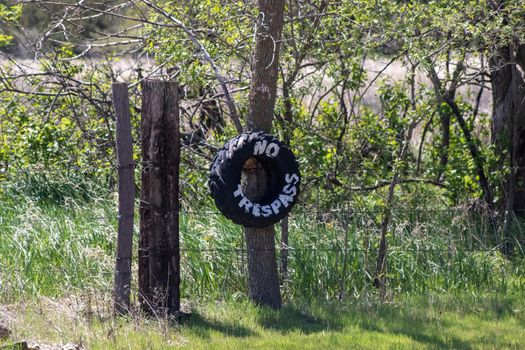 No Trespassing tire sign on barb wire fence . High quality photo