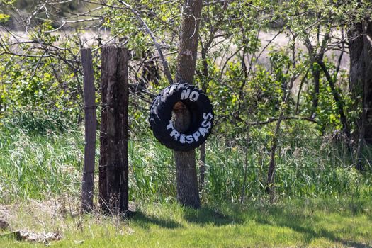No Trespassing tire sign on barb wire fence . High quality photo