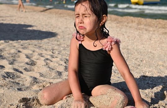 Active lifestyles and happy summer vacations. Adorable child, baby girl, having sunbathing, enjoying beautiful sunny day during summer holidays