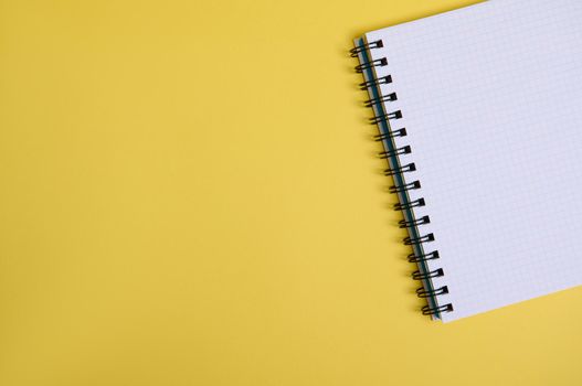 Flat lay a cropped organizer notepad with blank white sheets , isolated on yellow background with copy space for text