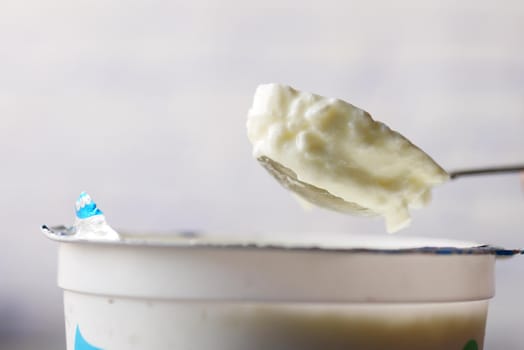 fresh yogurt on a spoon close up .