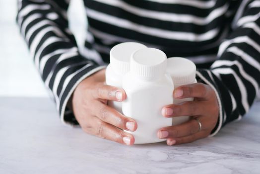 young man hand holding medicine pill container .