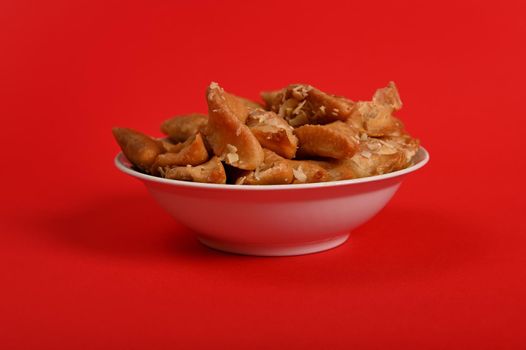 Horizontal shot of plate full of fresh traditional luxurious Arabian handmade Brewat sweets, isolated on red background with space for text