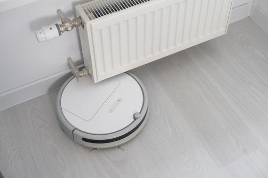 Robot vacuum cleaner performs automatic cleaning of the apartment at a certain time. Smart home.