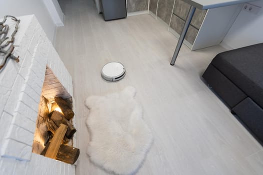 Modern robotic vacuum cleaner on floor in living room. Space for text.