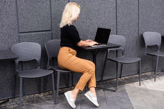 Young woman with laptop outside.