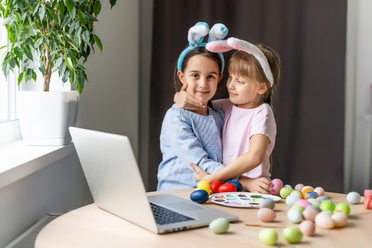 two little girls with ears hold eggs - Easter symbols. Easter egg