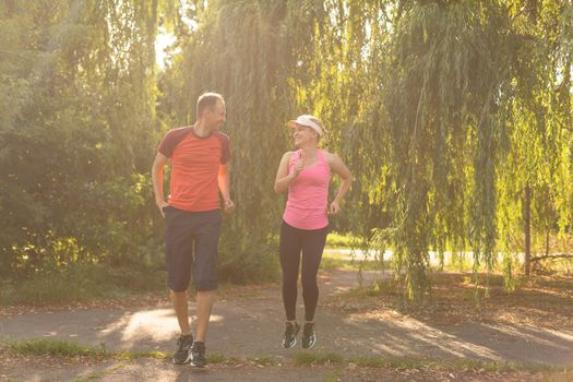 a woman and a man go in for sports in the forest.