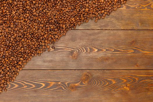 roasted coffee beans laid on brown wooden table surface with copy space