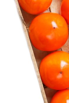 Fresh ripe persimmons in market. Persimmons background. Repeating rows of juicy, ripe persimmon in a box. Close-up, macro