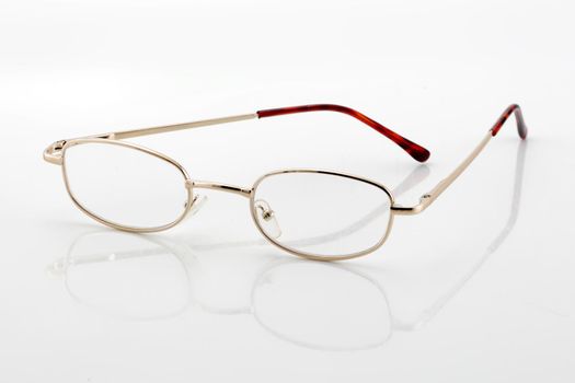 A pair of reading glasses on white background with shadow and differential focus