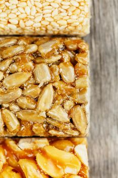 Assorted kozinaki, on the old vintage background. Country style. Delicious sweets from the seeds of sunflower, sesame and peanuts drenched in shiny glaze. Macro close up