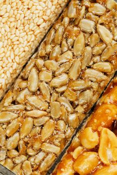 Assorted kozinaki, sweets from sunflower seeds, sesame and peanuts filled with brilliant glaze. Macro close up