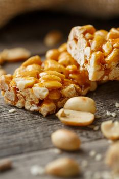 Assorted kozinaki, on old vintage background, with burlap fabric. Country style. Delicious sweets from the seeds of sunflower, sesame and peanuts, covered with shiny glaze. Macro, close-up