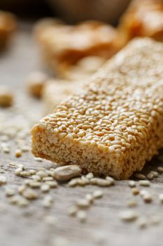 Sesame seed casinos on old vintage background with burlap cloth. Country style. Delicious sweets from seeds of sunflower, sesame and peanuts, covered with shiny glaze. Macro, macro, vertically