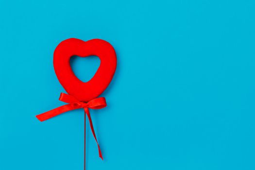 Red red heart with a bow on a blue background