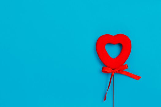 Red red heart with a bow on a blue background