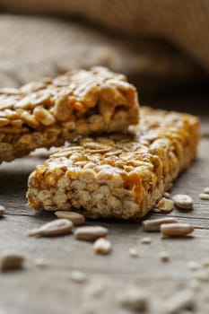 Casinac from sunflower seeds on old vintage background with burlap cloth. Country style. Delicious sweets from seeds of sunflower, sesame and peanuts, covered with shiny glaze. Macro, macro, vertically