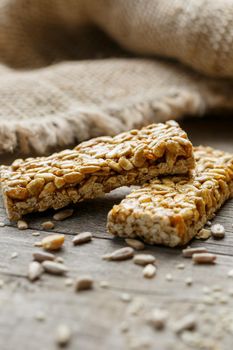 Casinac from sunflower seeds on old vintage background with burlap cloth. Country style. Delicious sweets from seeds of sunflower, sesame and peanuts, covered with shiny glaze. Macro, macro, vertically