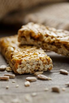 Casinac from sunflower seeds on old vintage background with burlap cloth. Country style. Delicious sweets from seeds of sunflower, sesame and peanuts, covered with shiny glaze. Macro, macro, vertically